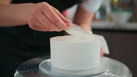 Close-up of someone applying flawless white icing to a cake Vídeos de archivo 336098085