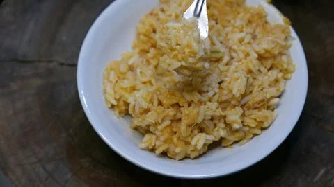 Close-up: someone eating risotto with a fork. A plate of risotto on the table Fotos de archivo