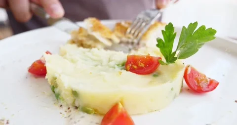 Close-up. someone eats with a knife and a fork cordon bleu with potato cream and Video stock 159566251