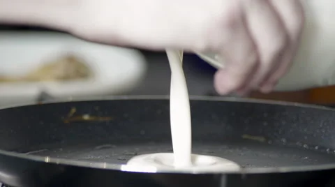 Close-up of Someone Pouring Pancake Batter into a Frying Pan Stock Footage 60019641