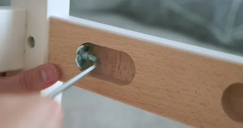 Close-up. someone screws a bolt with a screwdriver into a notch on a wooden Stock Footage 161831401