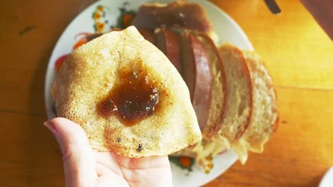 Close-up, someone spreads fig jam on a slice of roll with poppy seeds. Stock Footage 116573244