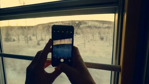 Close-Up of Someone Taking a Picture of Snow Covered Trees from Inside a Train Stock Footage