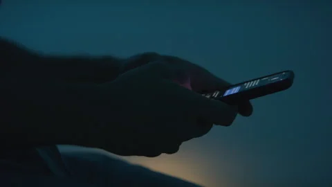 Close up of Someone Texting on Their Cell Phone in the Dark with a Yellow Light Видео 270388665