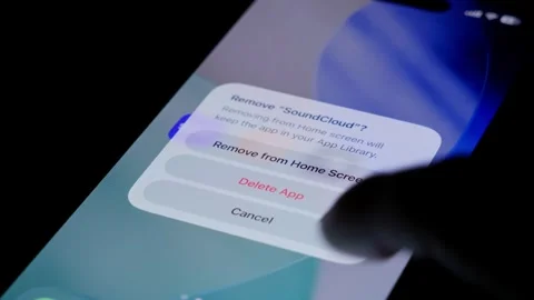 Close-up of the SoundCloud app being deleted from a smartphone home screen in a Stock Footage 334062897