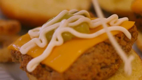 Close-up of Southern Fried Chicken Burger with Cheese as Mayonnaise is Drizzled Видео 345102746
