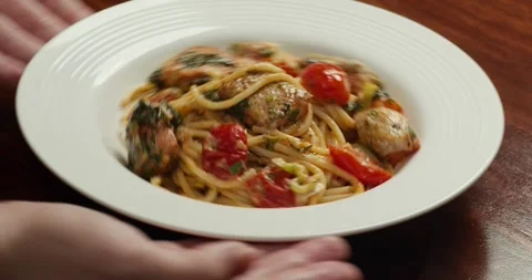 Close-up of spaghetti being plated with kitchen tongs in a white bowl. Pasta Vídeo Stock 329586285