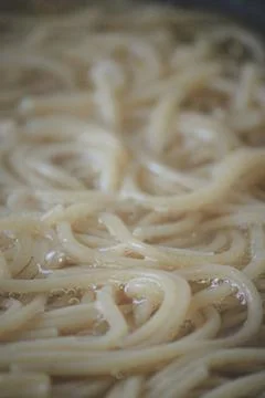 Close up of spaghetti boiling in water with bubbles and foam during the coo.. 스톡 사진
