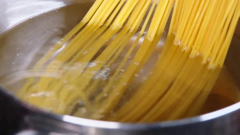 Close-up of spaghetti pasta In boiling hot water in steel pan on kitchen stove.  Stock Footage 179294388