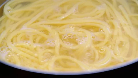 Close-up of spaghetti pasta in boiling hot water in steel pot. Cooking at home.  Vídeo Stock 179295441