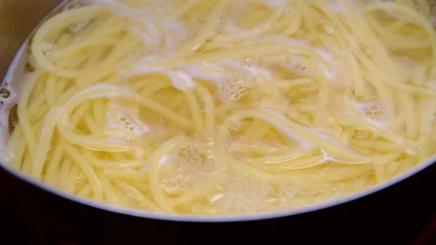 Close-up of spaghetti pasta in boiling hot water in steel pot. Cooking at home.  Stock Footage 179297004