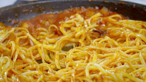 Close-up of spaghetti pasta mixed with red sauce in a hot pan. Stock Footage 277451874