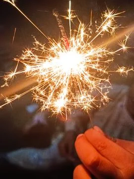 Close Up Sparkler Firework in Hands at Night with Bright Golden Sparks Stock Photos