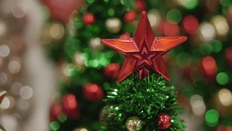 Close-up of sparkling red star on top of festive Christmas tree. Decorations. Video stock 294672762