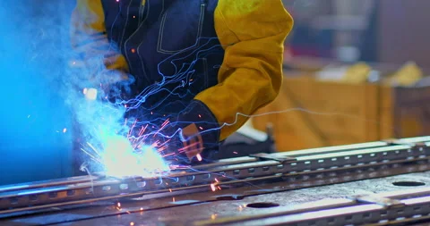 Close-up, sparks fly when welding metal. Worker welds metal products in Vídeo Stock 142835627
