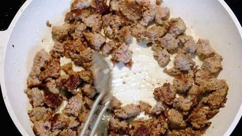 Close Up of Spatula Stirring Browning Minced Meat in Skillet Stock Footage 332254275