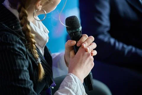 Close up of a speaker hands holding a wireless microphone during a conference Stock Photos