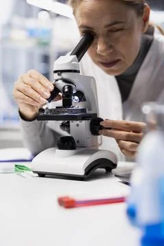 Close up of specialist checking product for defects using microscope Stock Photos
