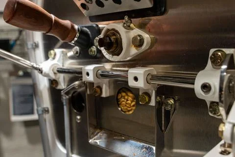 Close up on a specialty coffee roaster machine roasting raw coffee beans. Stock Photos