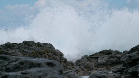 CLOSE UP: Spectacular foaming ocean wave sweeps the black rocks on remote island Stock Footage 91223811