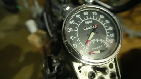 Close-up of speedometer and odometer on a vintage motorcycle in a garage Stock Footage 247020924