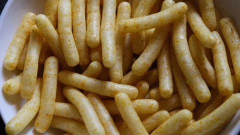 Close-up of Spiced Corn Puff Sticks in White Bowl 库存影片 331986660