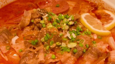 Close Up of Spicy Beef Noodle Soup with Tomato Broth and Lemon Stock Footage 339540810