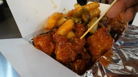Close-up of Spicy Korean Fried Chicken and Chewy Tteokbokki Rice Cakes in Takeou Video stock 343027484