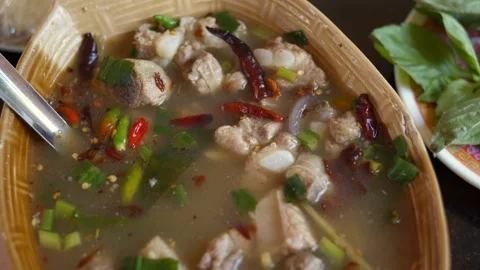 Close-up of spicy pork bone soup in a brown porcelain bowl Stock Footage 275592370
