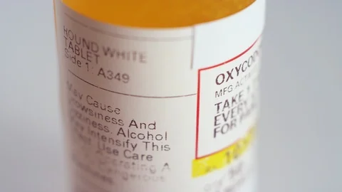 Close-up of a spinning bottle of oxycodone pills label on a white background Stock-Footage 119090839