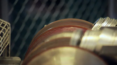 Close up spinning capping wheel feeding metal caps. Dairy food plant machinery. Stock Footage 347093491