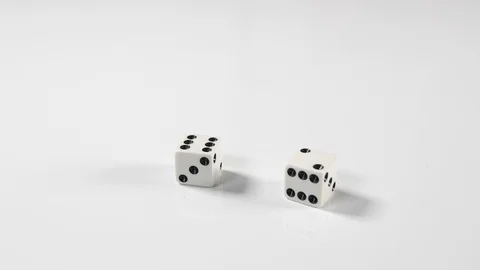 Close up of spinning dice thrown onto a white surface background, above macro Stock Footage 89192874