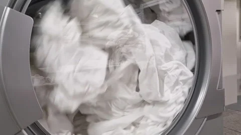 Close-up of the spinning drum of a washing machine washing dirty bed linen. Stock Footage 240842857