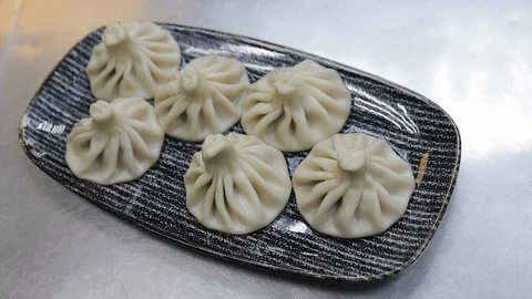 Close up of spinning plate of delicious khinkali dumplings Stock Footage 128661106