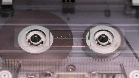 Close-up of spinning reels inside compact cassette in a vintage tape recorder Stock Footage 302969485