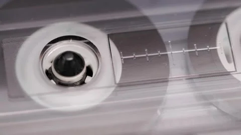 Close-up of spinning reels inside compact cassette in a vintage tape recorder Stock Footage 303138650