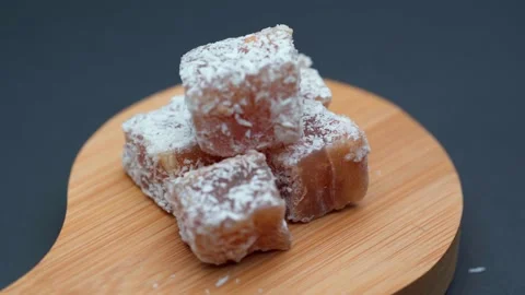 Close-up spinning Turkish delight stuffed with nuts in coconut flakes. Stock Footage 153503254