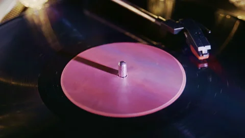 Close Up of Spinning Vinyl Record with Purple and Warm Lights Stock Footage 345399129