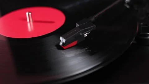 Close-up of a spinning vinyl record with a red label on a turntable Stock Footage 339000861