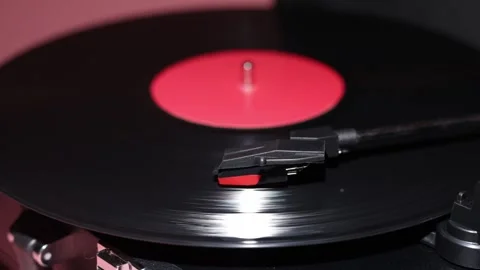 Close-up of a spinning vinyl record with a red label and tonearm Stock Footage 339001431