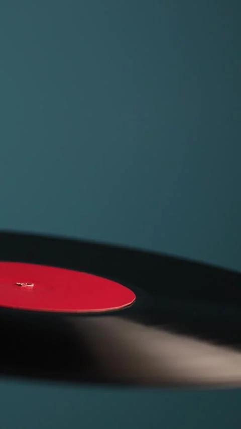 Close-up of a spinning vinyl record with a red label on a blue background Vidéo 343838200