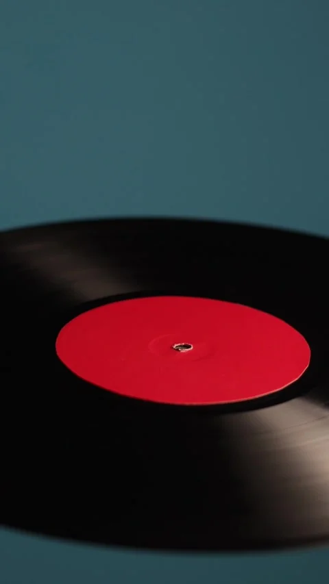 Close-up of a spinning vinyl record with a red label on a blue background Vidéo 343838204