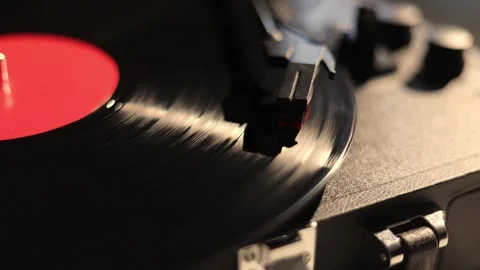 Close-up of a spinning vinyl record on a turntable with a red label Stock Footage 337104437