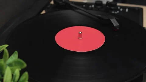 Close-up of a spinning vinyl record on a turntable with a red label Vidéo 340844888
