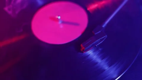 Close-up of a spinning vinyl record with vibrant neon lighting and a stylus Stock Footage 339002932