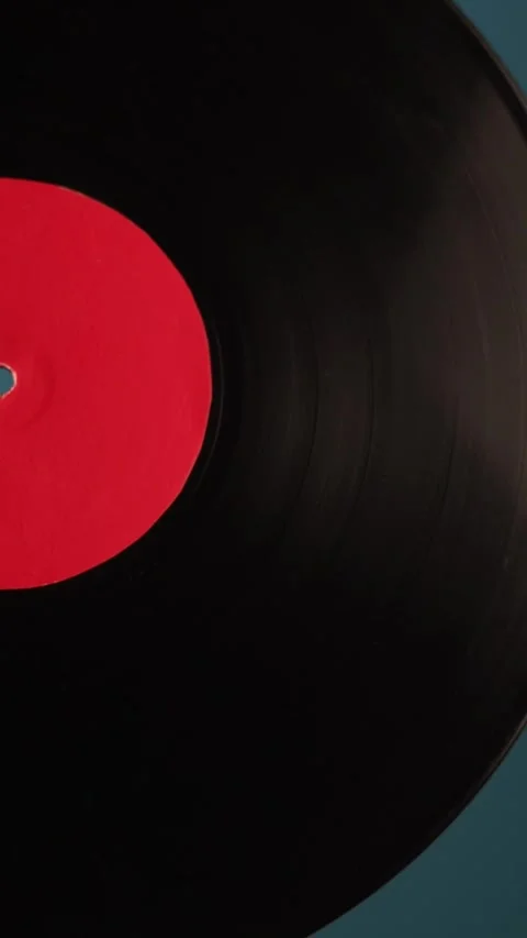 Close-up of spinning vinyl records with red labels on a blue background Vidéo 343838196
