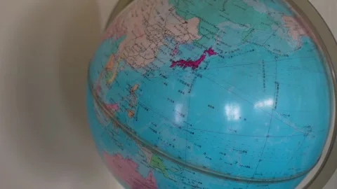 Close-up of spinning world globe focusing on Japan with Japanese text Stock Footage 346349556