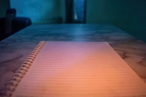 Close up of a spiral notebook with blank lined pages on a marble table. The.. Fotos de archivo