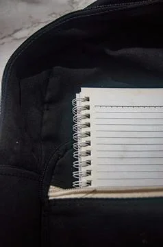 Close up on a spiral notebook with lined pages, partially inside a black ba.. Fotos Stock