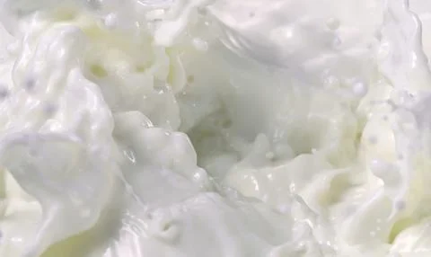A close-up of a splash of white liquid, possibly milk or cream Stock Photos